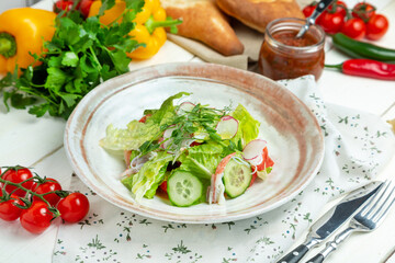 Crab meat salad with fresh vegetables in a plate, restaurant. Horizontal frame.