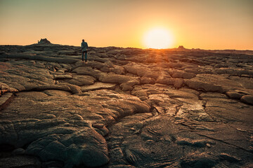 Man walking on solidified lava in Erta Ale volcano in Afar region, Ethiopia