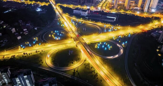 track aerial time lapse video of the night view of cloverleaf interchange