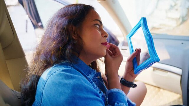 Model apply rouge on cheek as seated inside vehicle