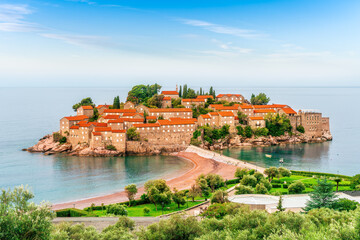 picturesque seascape of beautiful isle Sveti Stefan near Budva Montenegro. Scenic orange buildings...