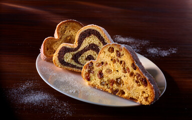 Stollen auf weissem Teller und dunklem Fond, Kuchen, Stollenscheiben, Rosinen, Weihnachten, 