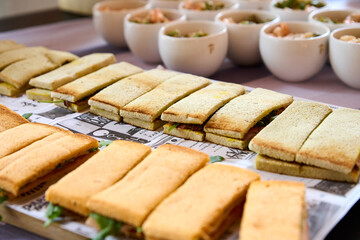 sandwiches with salmon, cheese and lettuce on a wooden board
