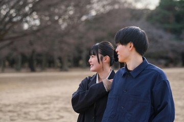 公園で寄り添う笑顔の若いカップル