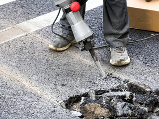 Asphalt Repair in Action: Professional Worker Using Pneumatic Jackhammer
