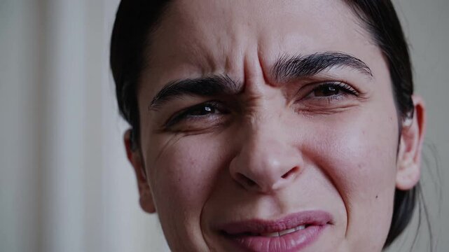 The expressive face of a woman contorted in deep frustration, annoyance, or disgust, with a wrinkled nose.