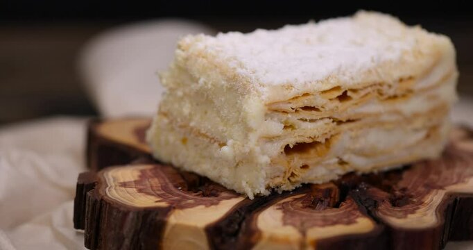 cake with white buttercream , a sweet piece of dessert cake made of alternating layers of dough and sweet filling