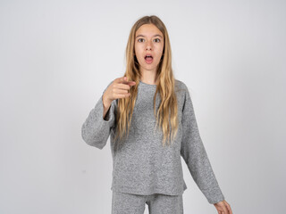 Shocked beautiful caucasian girl wearing grey track-suit points at you with stunned expression