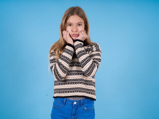 Portrait of sad beautiful caucasian girl wearing striped sweater hands face
