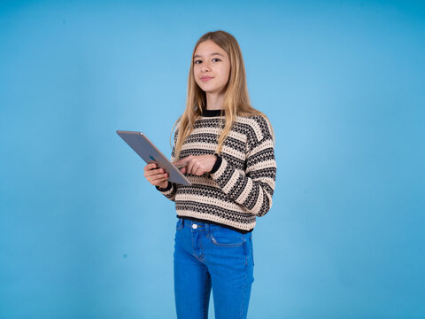 Photo of happy cheerful smart beautiful caucasian girl wearing striped sweater hold tablet browsing internet