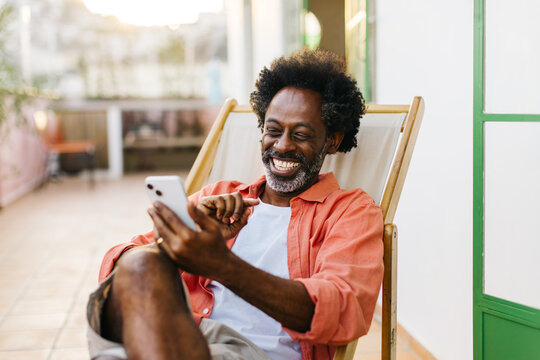 Mature man smiling during an outdoor video call on his smartphone - Powered by Adobe