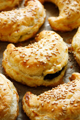 Close-up view of sesame-sprinkled croissants,  crescents with vegetarian spinach-cheese filling

