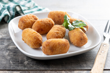 Fried cod croquettes on wooden table