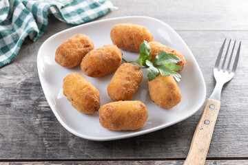 Fried cod croquettes on wooden table
