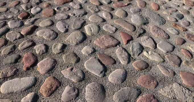 a part of the road made of cobblestones, an old-style pavement made of cobblestones of different sizes