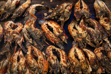 Delicious lobsters grilling on a hot barbecue grill, BBQ Grilled Lobster Tail, close up.