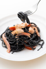 spaghetti with cuttlefish ink and seafood dish on a plate