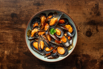Mussels, moules mariniere, overhead flat lay shot on a wooden background, seafood appetizer