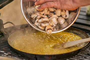 The chef prepares a traditional seafood paella on the grill.Traditional spanish dish. Fresh and Colorful Spanish Seafood Paella. Mediterranean cuisine and seafood dishes.