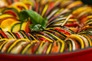 Chef preparing traditional Provençal vegetable dish Ratatouille with stuffed rolled meat on the grill. French food. Healthy eating. Delicious vegetable