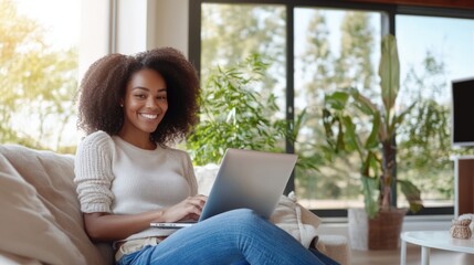 Working woman smiling at laptop on couch in modern living room home office environment inspirational lifestyle concept