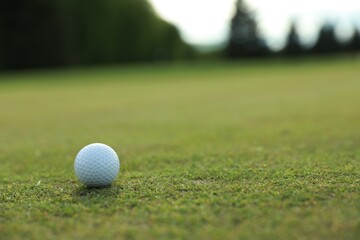 Golf ball on green course, space for text