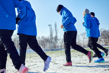 Speed and Coordination. Close-up of young footballers in synchronized motion, running together on...