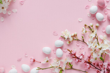Spring easter background in shades of pink with blooming branches and sugar easter eggs. 