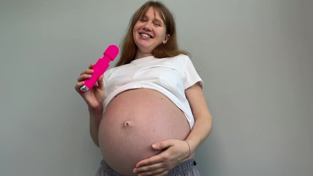 pregnant woman holding pink vibrator