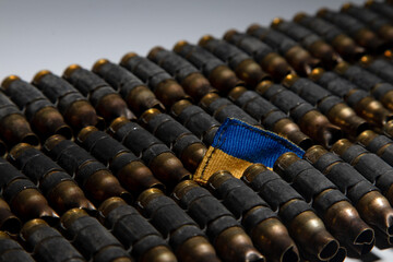 several rows of bullet casings in the middle of which part of the Ukrainian flag is visible