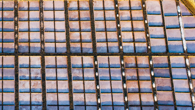Aerial view of salinas del carmen salt field at sunset with beautiful patterns and reflections, Fuerteventura Island, Canary Islands, Spain.