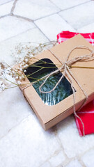 Rustic gift box with window, tied with twine and decorated with dried flowers on marble surface