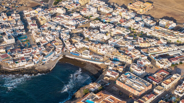 Aerial view of el Cotillo town with picturesque buildings and coastal waves, Fuerteventura Island, Canary Islands, Spain.