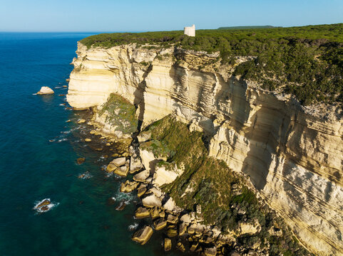 Aerial view of rugged cliffs and turquoise ocean with scenic rocks, Nature Reserve La Brena y Marismas del Barbate, Cadiz, Spain.