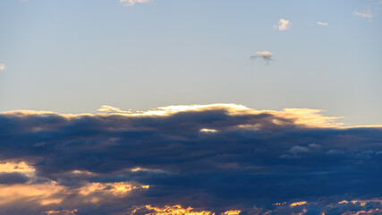 Thick cloud with golden sunlight in the background, dawn sky