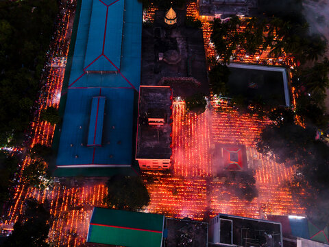 Aerial view of the illuminated Shri Shri Loknath Brahmachari Ashram during the Rakher Upobash festival with a vibrant crowd and smoke, Narayanganj, Dhaka, Bangladesh.