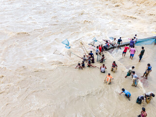 Feni, Bangladesh - 27 August 2024: Aerial view of fishing community with handmade nets in flood water, Feni River, Feni, Chittagong, Bangladesh.