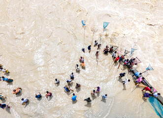 Feni, Bangladesh - 27 August 2024: Aerial view of people fishing with handmade nets in flood water near Feni river, Chittagong, Bangladesh.