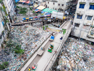 Keraniganj, Bangladesh - 03 July 2024: Aerial view of polluted urban landscape with busy streets, shopkeepers, and a canal, Aganagar, Keraniganj, Dhaka, Bangladesh.
