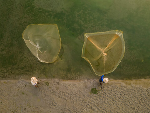 Aerial view of local fishermen net fishing on the Teesta river with vibrant aquatic livelihood and sustainable fishing practices, Rangpur, Bangladesh.