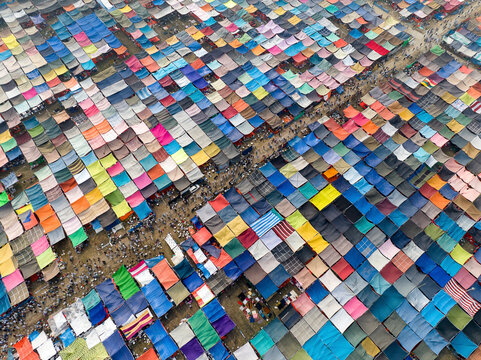 Aerial view of a vibrant and crowded local market with multicolored tents and busy vendors, Tongi, Gazipur, Bangladesh.