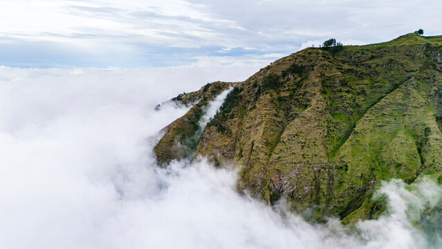 Aerial drone view clouds rolling onto Rinjani volcano on the island of Lombok, Indonesia
