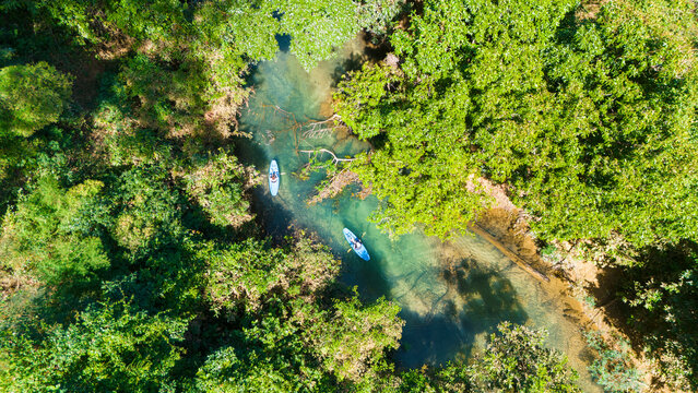 Aerial drone view of kayaks in transparant water near Kong Lor cave, Laos, Southeast Asia