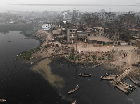 Aerial view of Buriganga river with crowded urban buildings and boats along the riverbank, Lalbagh Thana, Dhaka, Bangladesh.
