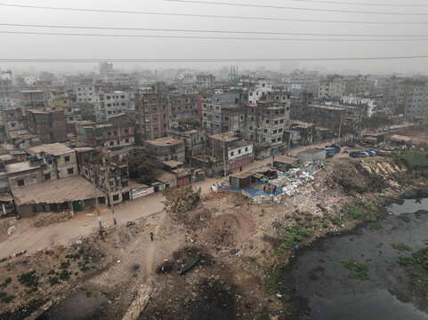 Aerial view of densely populated urban landscape with Buriganga river and high-rise buildings, Lalbagh Thana, Dhaka, Bangladesh.