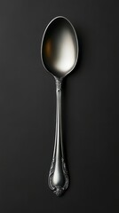 Elegant stainless steel spoon displayed on a dark background showcasing its intricate handle design and polished surface