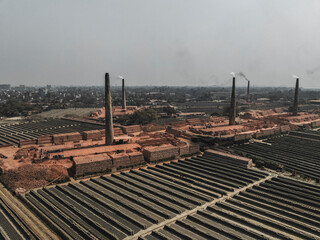 Aerial view of industrial brick fields and factories with chimneys emitting smoke, Baktaballi, Narayanganj, Dhaka, Bangladesh.