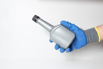 car bottle in the hand in a blue glove