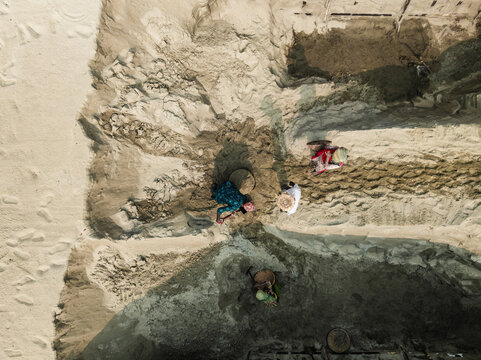 Aerial view of a bustling work site with people, boats, and cement industries, Darus Salam Thana, Dhaka, Bangladesh.