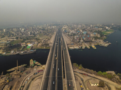 Aerial view of a busy urban landscape with a bridge and road over a river, Darus Salam Thana, Dhaka, Bangladesh.